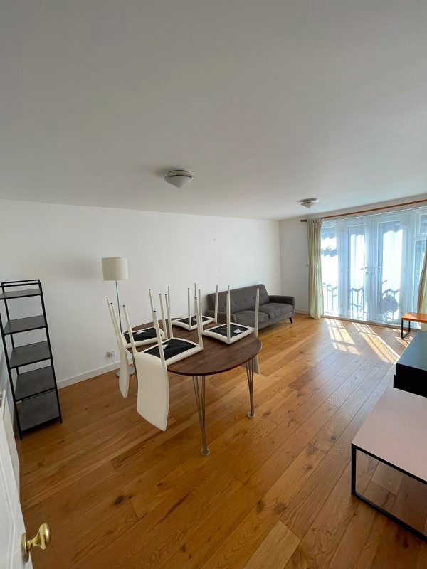 Living room cleaned by CORES in London — wooden floor cleaned throughout, chairs stacked on the table